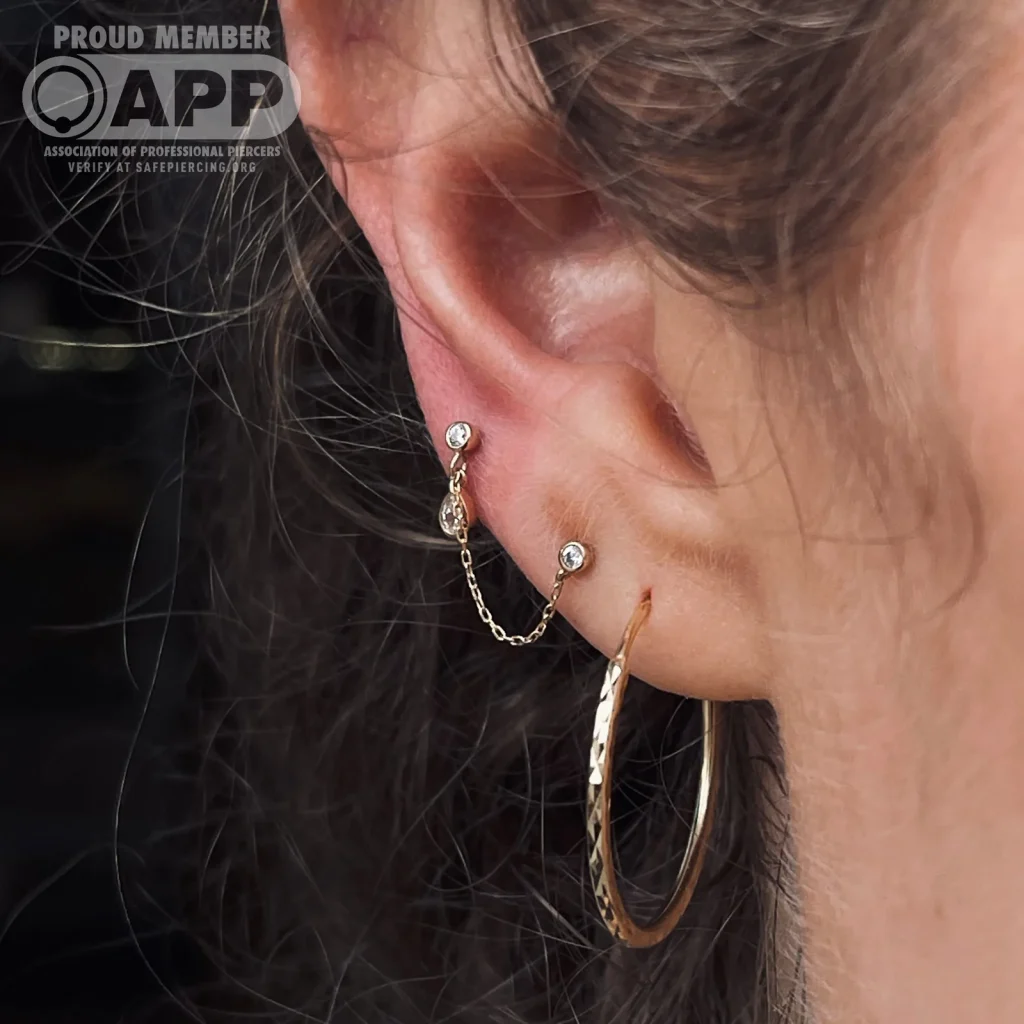 Curated ear with double lobe piercings and gold jewellery — URBAN BODY studio, Tel Aviv