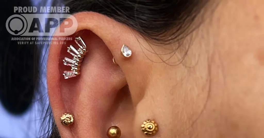 Curated ear with multiple helix piercings and gold jewelry at URBAN BODY Tel Aviv